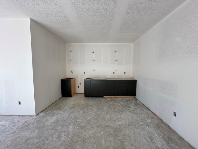 interior space with a textured ceiling and concrete floors