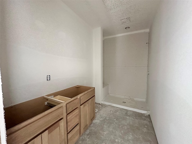 bathroom featuring unfinished concrete floors and a textured ceiling