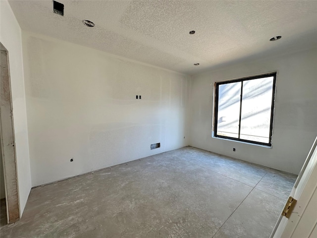 spare room with a textured ceiling