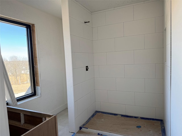 full bath with a tile shower and a wealth of natural light