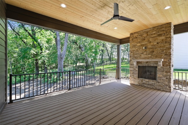 10430 Thorne Dr, West Des Moines, IA 50266 - wooden terrace with an outdoor stone fireplace, a ceiling fan, and view of scattered trees
