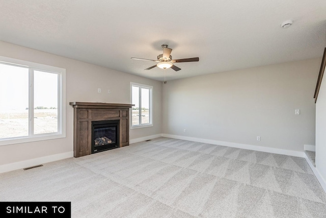 unfurnished living room with light colored carpet and ceiling fan