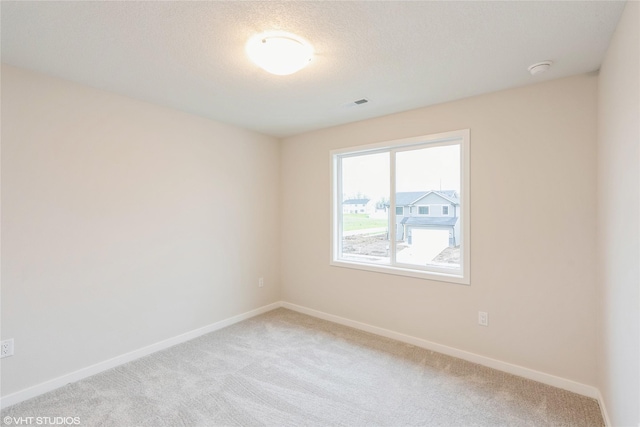 unfurnished room with baseboards, visible vents, and light colored carpet