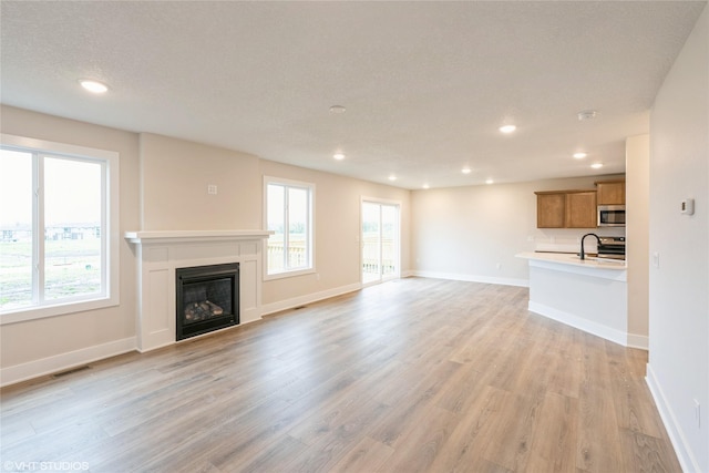 unfurnished living room featuring recessed lighting, visible vents, and light wood-style floors