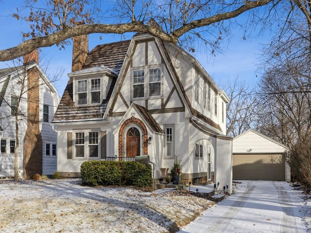 english style home with a garage and an outdoor structure