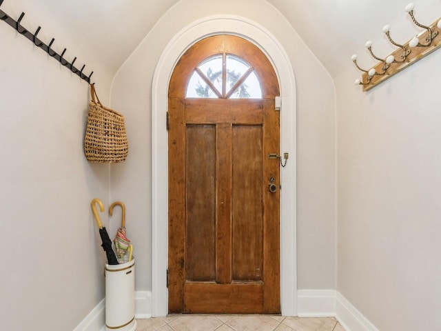 foyer featuring vaulted ceiling and light tile patterned floors