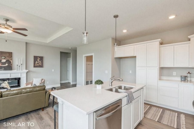 kitchen with white cabinetry, sink, an island with sink, and dishwasher