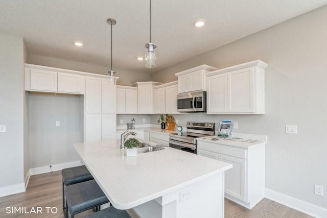 kitchen with sink, a center island with sink, white cabinets, and appliances with stainless steel finishes