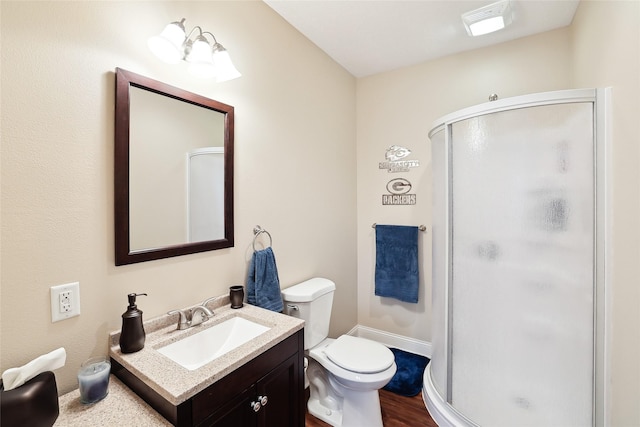 14102 Ridgemont Dr, Urbandale, IA 50323 - full bath with wood finished floors, toilet, vanity, baseboards, and a stall shower