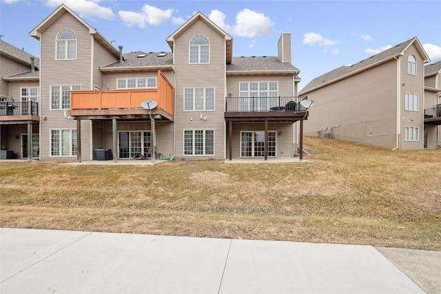 back of house with a wooden deck, central AC, a patio area, and a lawn