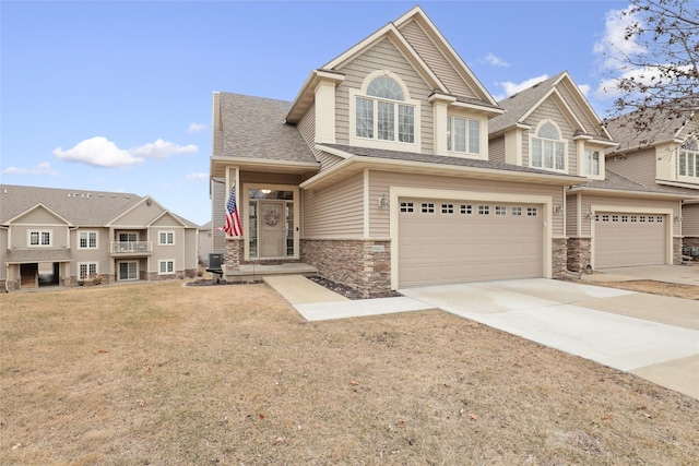 14102 Ridgemont Dr, Urbandale, IA 50323 - view of front of home featuring concrete driveway, stone siding, a front yard, and a garage