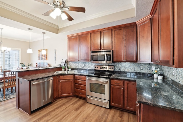 14102 Ridgemont Dr, Urbandale, IA 50323 - kitchen with a sink, ceiling fan with notable chandelier, light wood-style flooring, a peninsula, and appliances with stainless steel finishes
