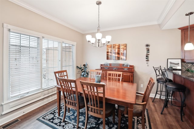 14102 Ridgemont Dr, Urbandale, IA 50323 - dining room with visible vents, an inviting chandelier, ornamental molding, and dark wood finished floors