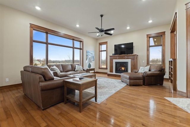 living room with plenty of natural light, ceiling fan, and light wood-type flooring