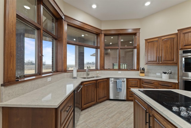 kitchen featuring tasteful backsplash, sink, stainless steel appliances, and light stone countertops