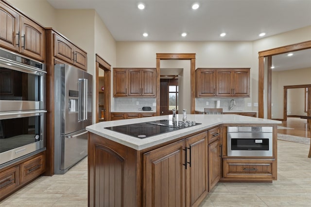 kitchen featuring decorative backsplash, appliances with stainless steel finishes, sink, and a kitchen island