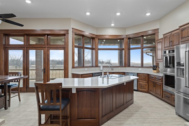 kitchen featuring a kitchen island, appliances with stainless steel finishes, sink, a breakfast bar area, and ceiling fan