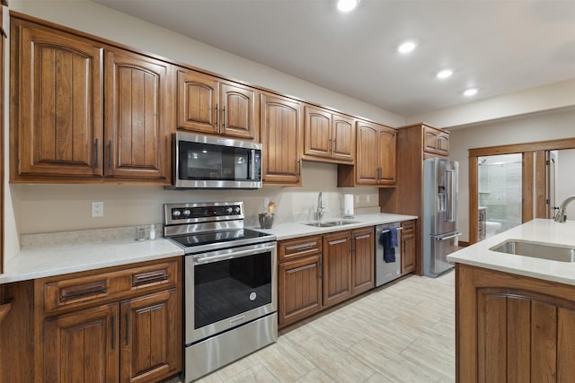 kitchen featuring stainless steel appliances, light stone countertops, and sink