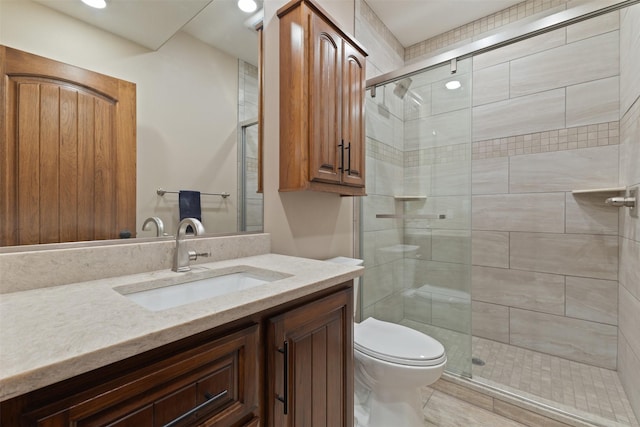 bathroom with vanity, a shower with shower door, and toilet