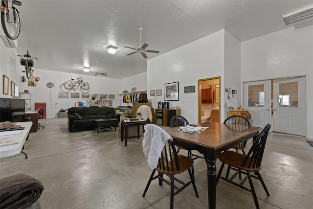 dining area featuring ceiling fan and a high ceiling