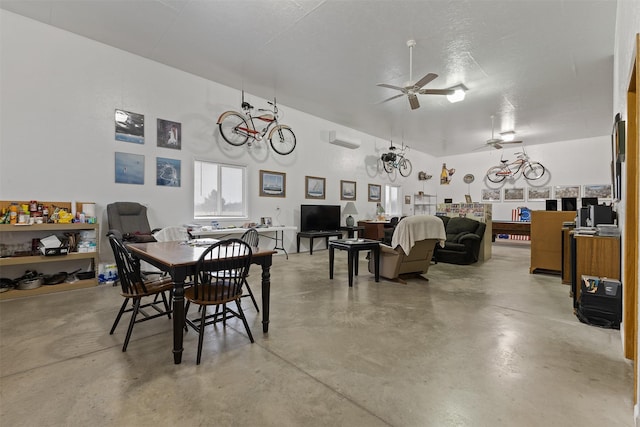 dining area with a towering ceiling, an AC wall unit, and ceiling fan