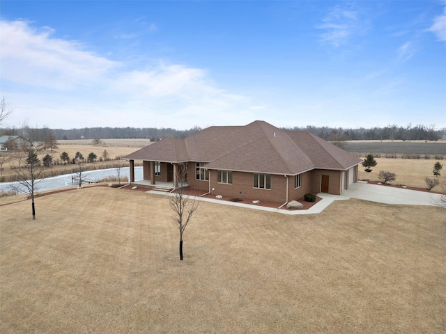 view of front of house with a porch, a front yard, and a rural view