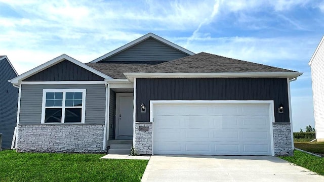 craftsman-style house featuring a garage and a front lawn