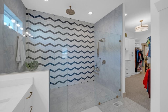 bathroom with tiled shower and vanity