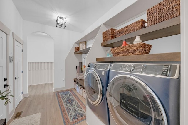 laundry room featuring separate washer and dryer and light wood-type flooring