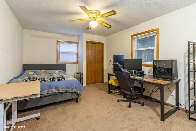 bedroom featuring ceiling fan, carpet, a textured ceiling, and a closet