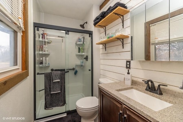 bathroom featuring vanity, toilet, and walk in shower