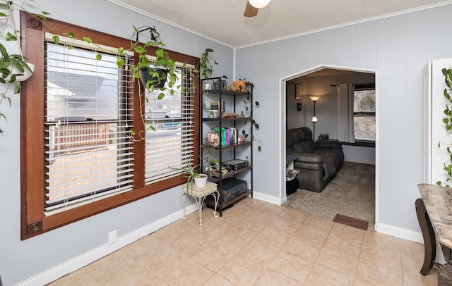 interior space featuring light tile patterned floors, ornamental molding, and ceiling fan