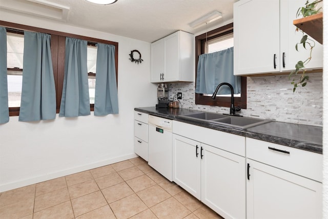 kitchen with white dishwasher, sink, and white cabinets