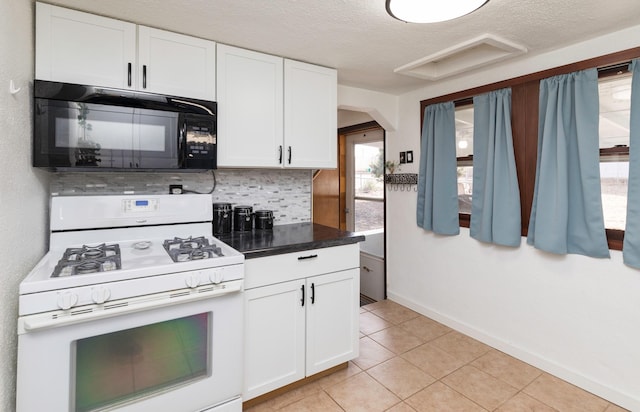 kitchen with white cabinetry, a textured ceiling, light tile patterned flooring, white gas range, and decorative backsplash