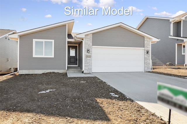 view of front of home with a garage, concrete driveway, and stone siding