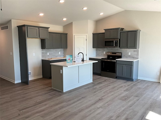 3423 5th Ave SE, Altoona, IA 50009 - kitchen featuring stainless steel appliances, backsplash, a sink, light countertops, and lofted ceiling