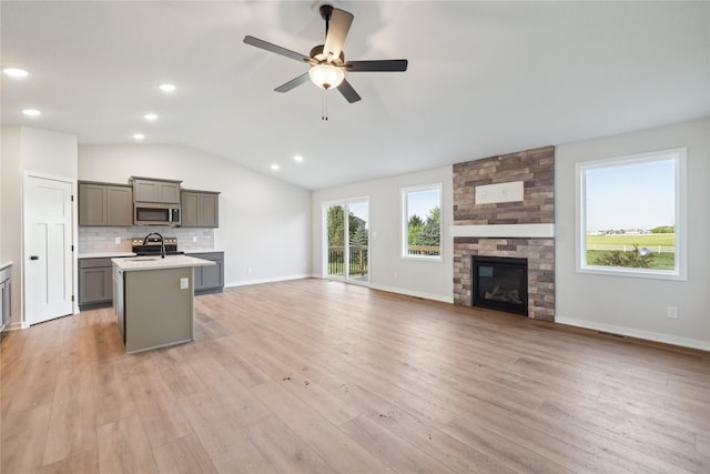 3423 5th Ave SE, Altoona, IA 50009 - unfurnished living room with a ceiling fan, vaulted ceiling, light wood-type flooring, a fireplace, and recessed lighting