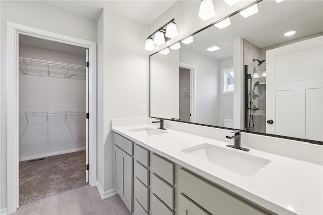 3423 5th Ave SE, Altoona, IA 50009 - bathroom with double vanity, a walk in closet, a shower, and tile patterned floors