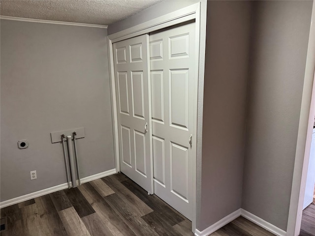 washroom featuring electric dryer hookup, washer hookup, dark wood-type flooring, and a textured ceiling