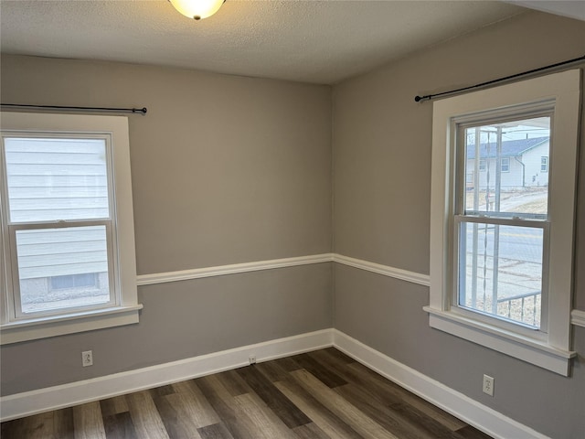 unfurnished room featuring dark hardwood / wood-style flooring and a textured ceiling