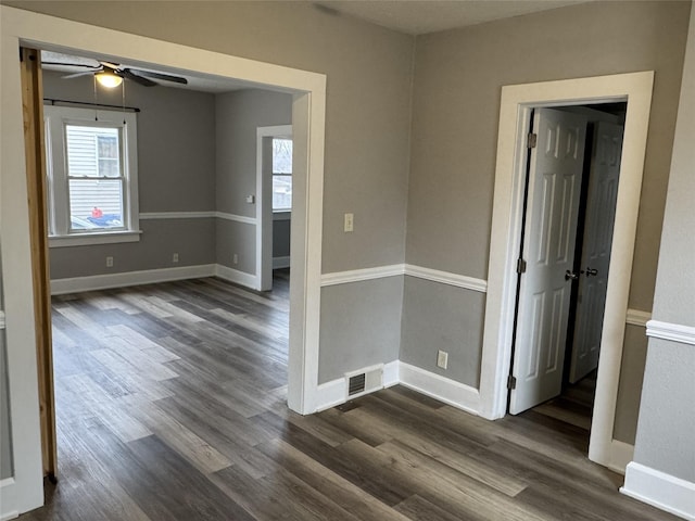 spare room featuring ceiling fan, dark hardwood / wood-style floors, and a wealth of natural light