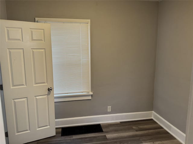 empty room with dark hardwood / wood-style flooring