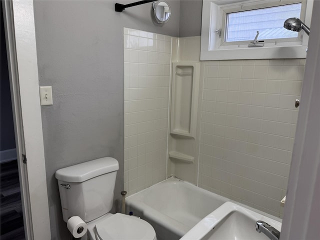 bathroom featuring shower / bathtub combination and toilet