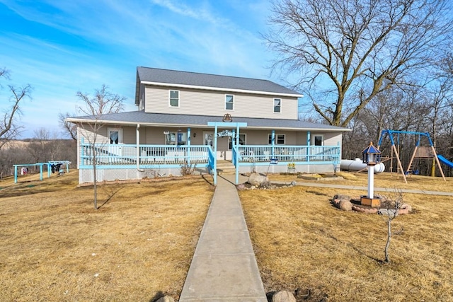 farmhouse inspired home featuring a front lawn, a playground, and a porch