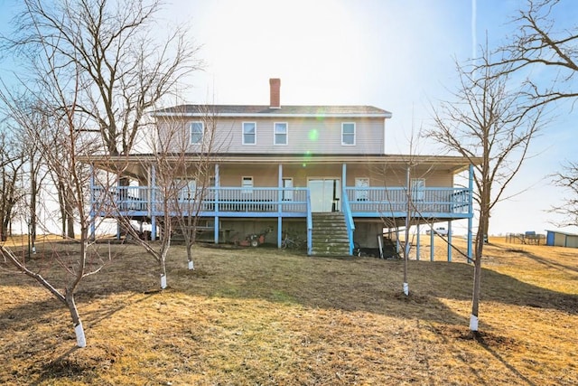 back of property with a porch and a lawn