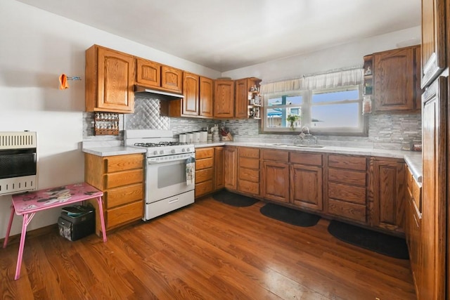 kitchen with sink, dark hardwood / wood-style floors, heating unit, white gas range, and decorative backsplash