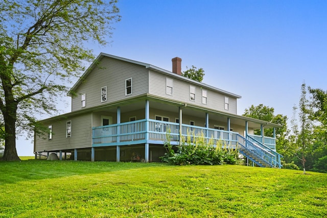 2466 655th Ave, Albia, IA 52531 - rear view of house with covered porch, a lawn, and a chimney