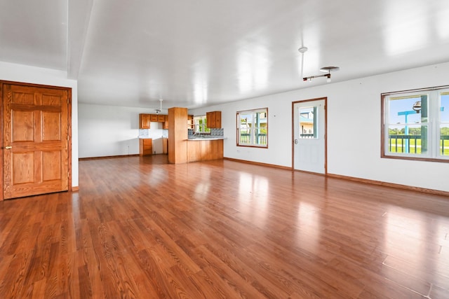 2466 655th Ave, Albia, IA 52531 - unfurnished living room featuring dark wood finished floors and baseboards