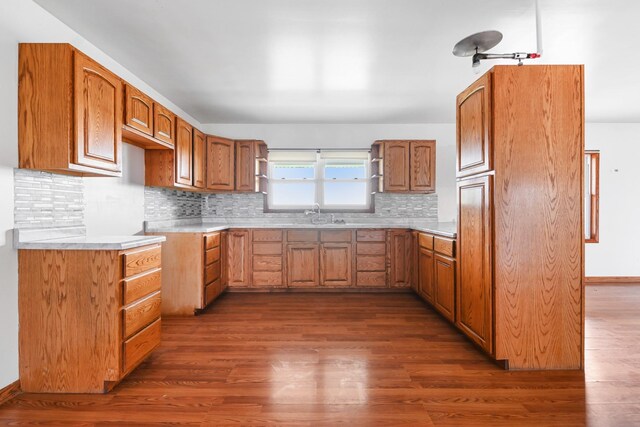 2466 655th Ave, Albia, IA 52531 - kitchen with dark wood-type flooring, open shelves, tasteful backsplash, and brown cabinetry