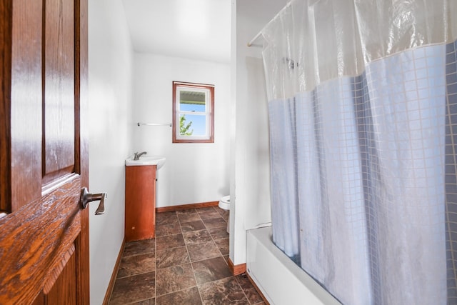 2466 655th Ave, Albia, IA 52531 - bathroom with baseboards, vanity, stone finish flooring, toilet, and shower / bath combination with curtain